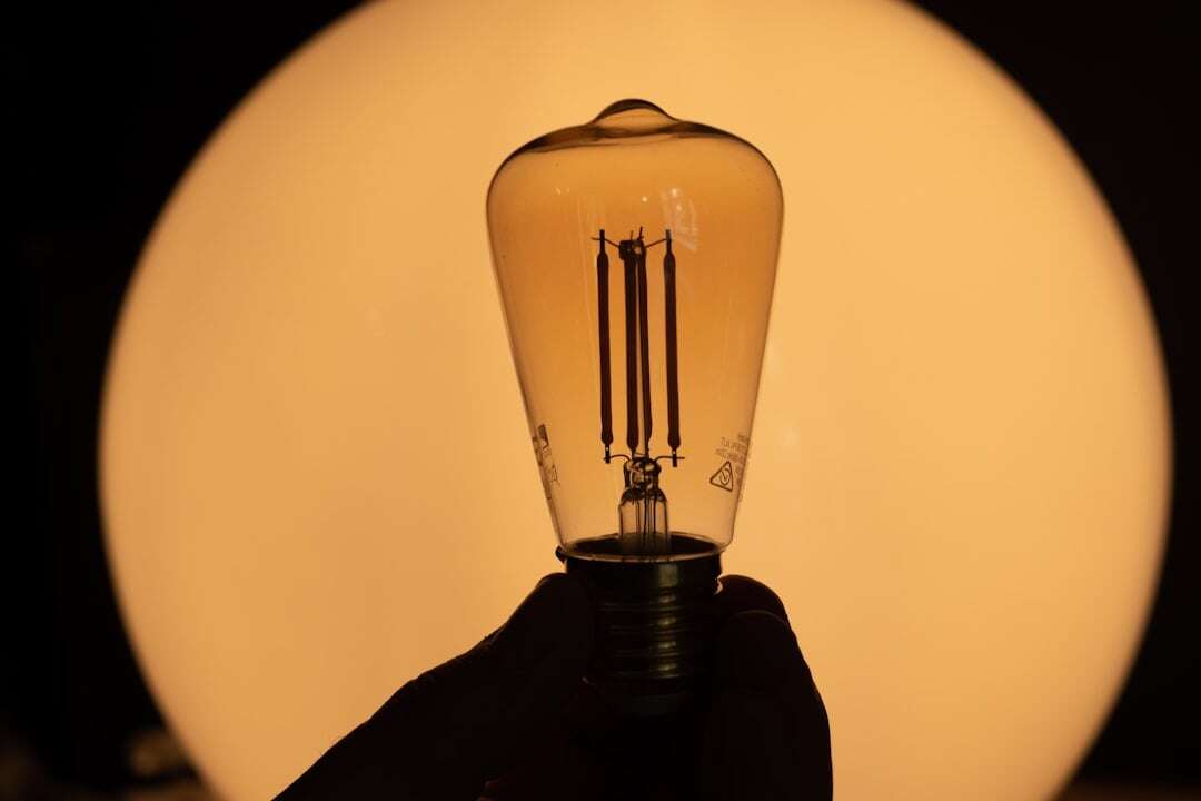 old fashioned lightbulb with light orange background