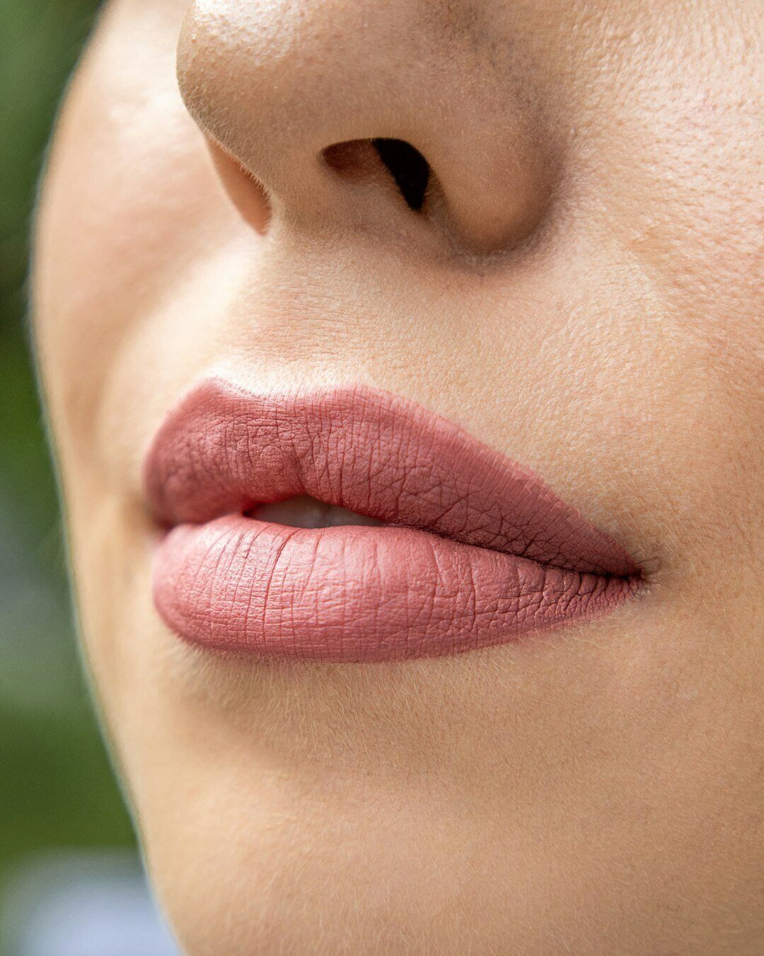 close up of lower part of woman's face highlighting pink lips