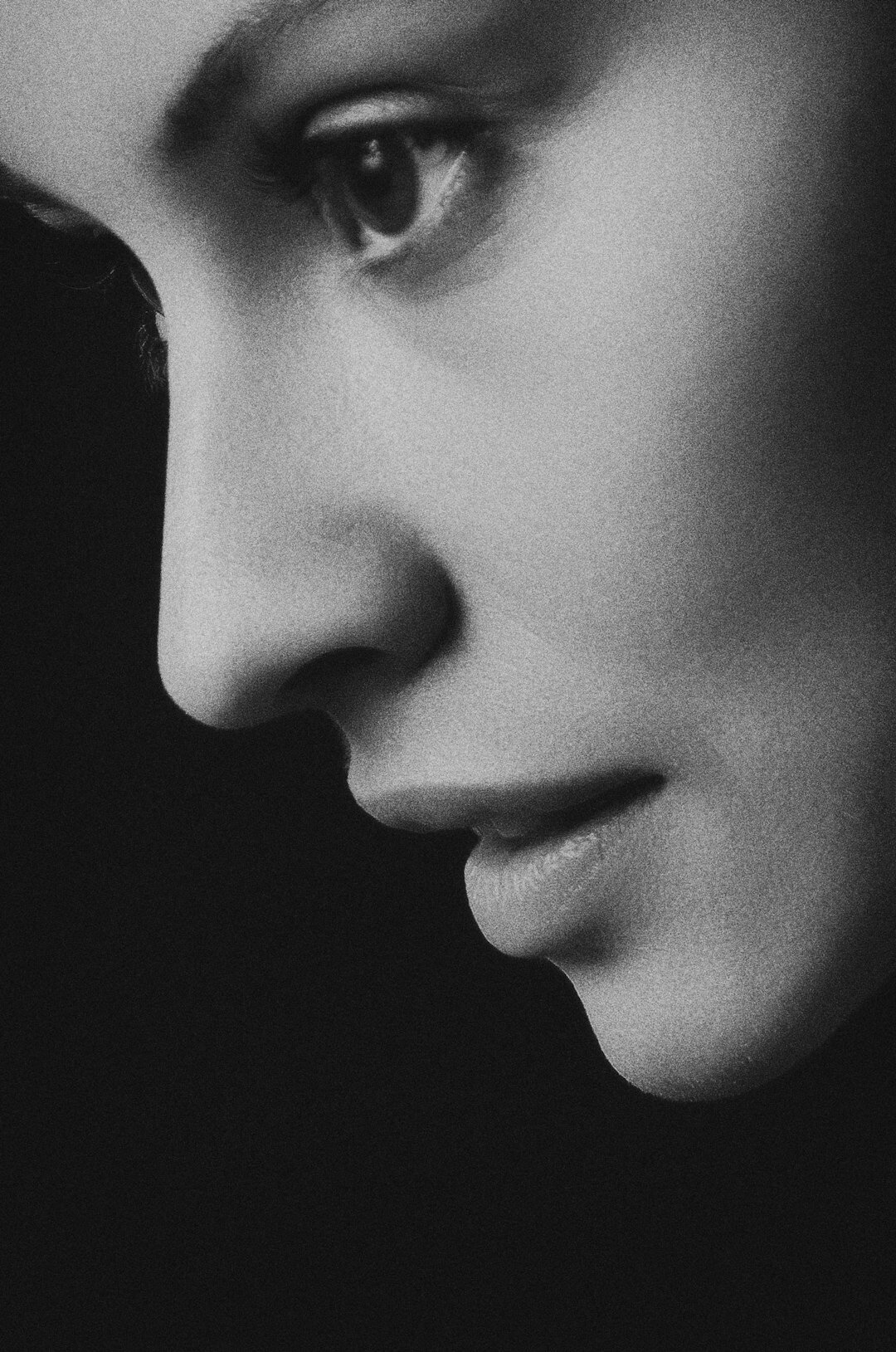 black and white photo with black background and profile of women's face