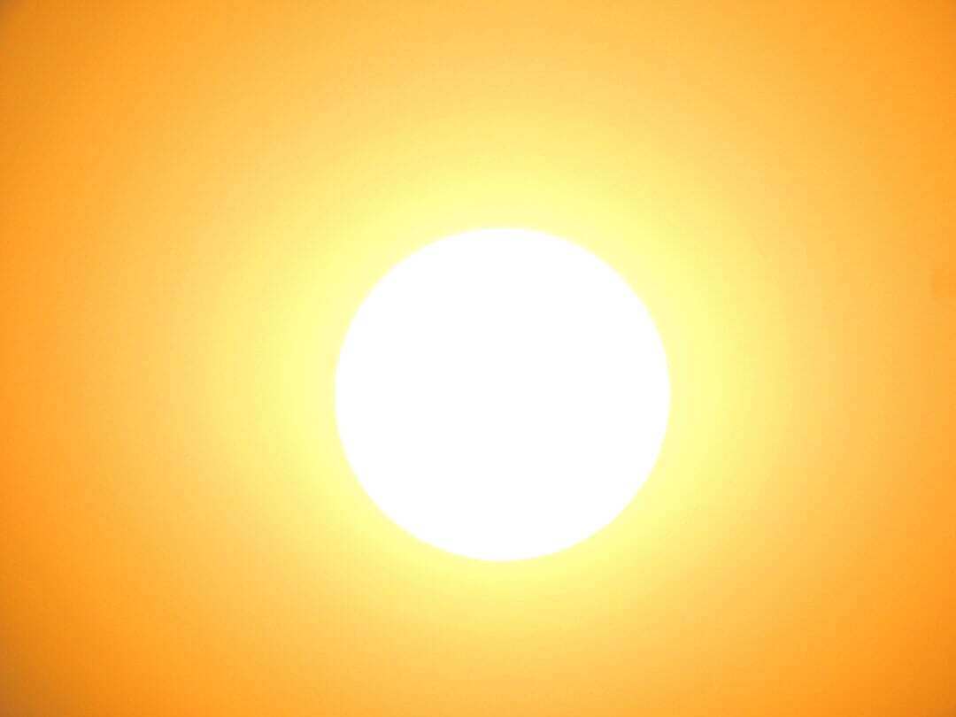 bright sun almost white with a yellow orange background