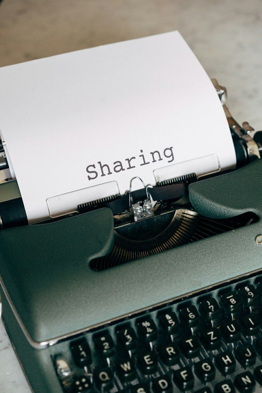typewriter with paper coming out from it with the word sharing