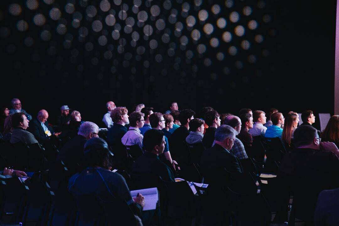 dark auditorium with audience staring at lighted stage