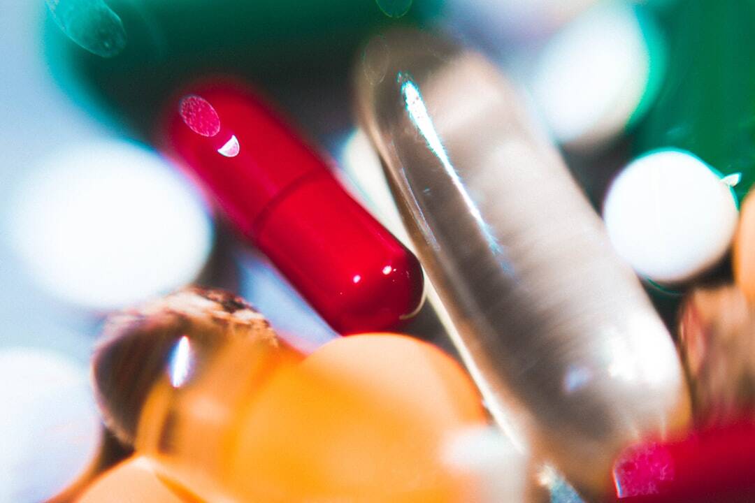 closeup of a red capsule and a white capsule