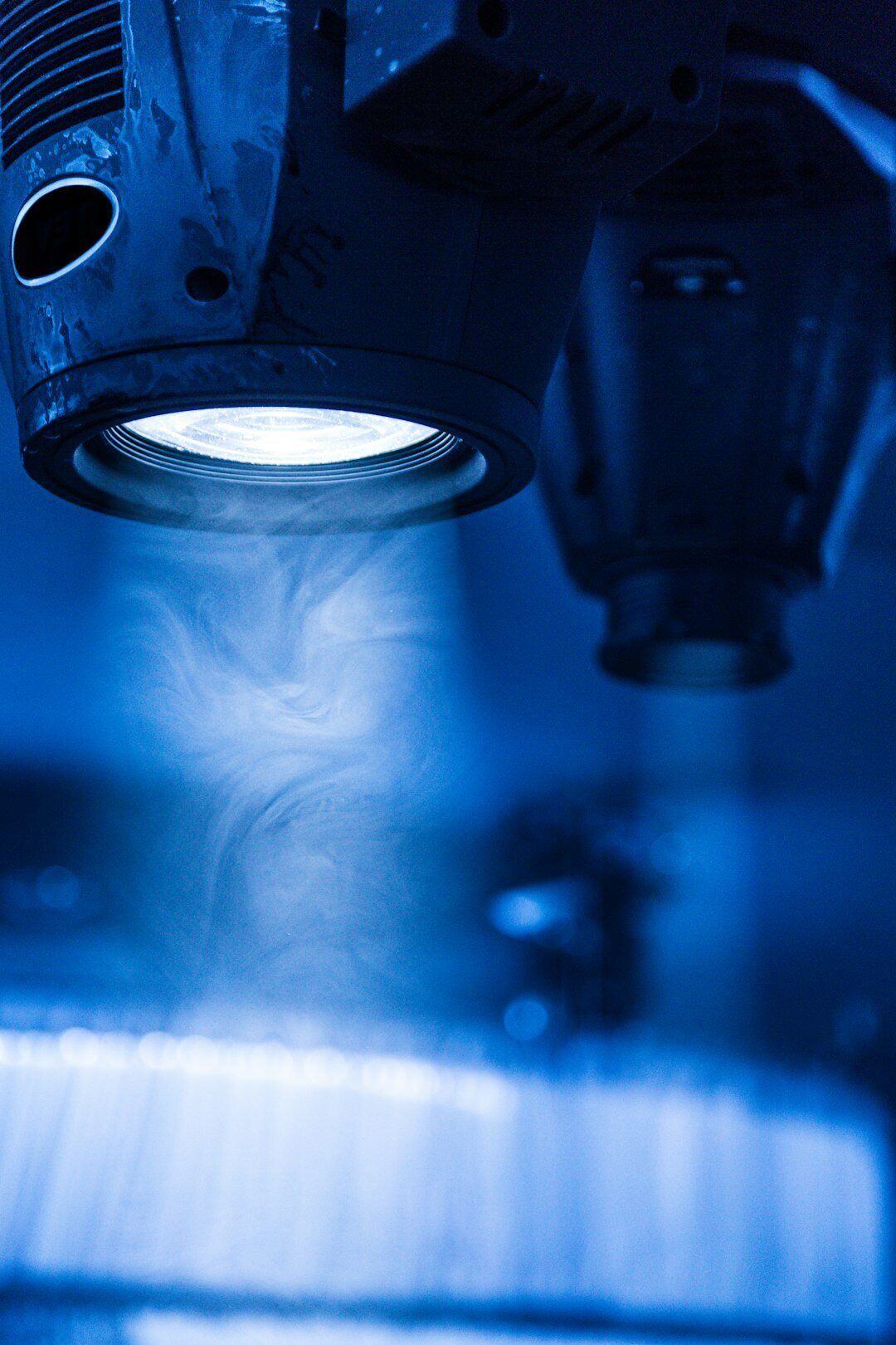 close up of microscope lens with a blue smoky background