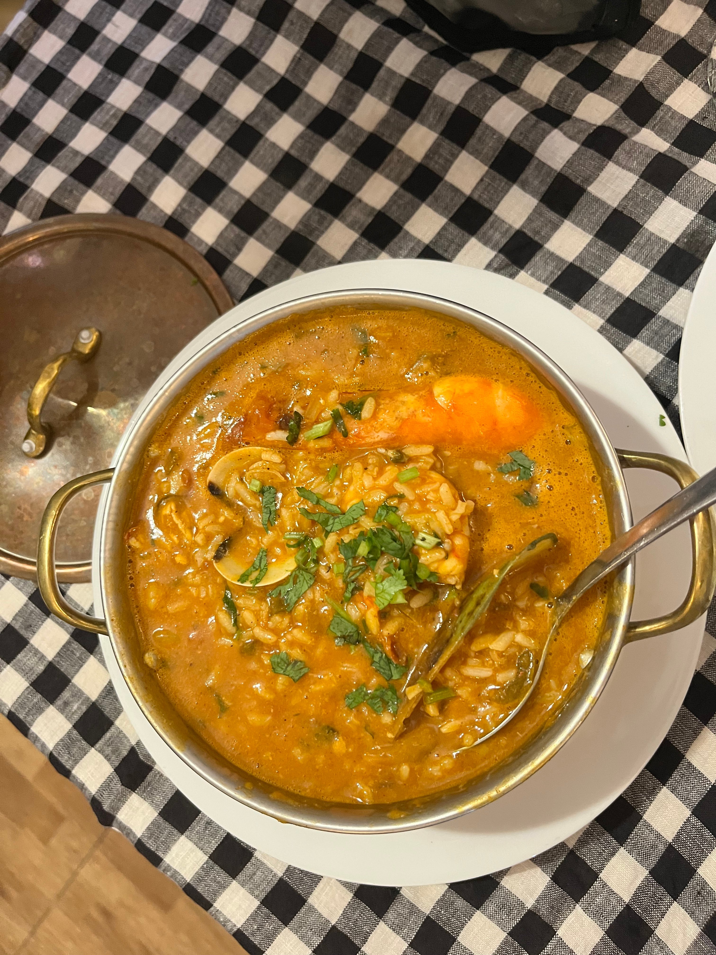 bowl of orange soup with black and white checkered tablecloth